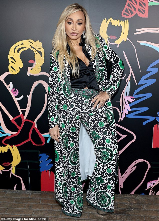 Karen Huger stood out in a tri-color patterned jacket and matching trousers, both of which were offset by a black velvet blouse