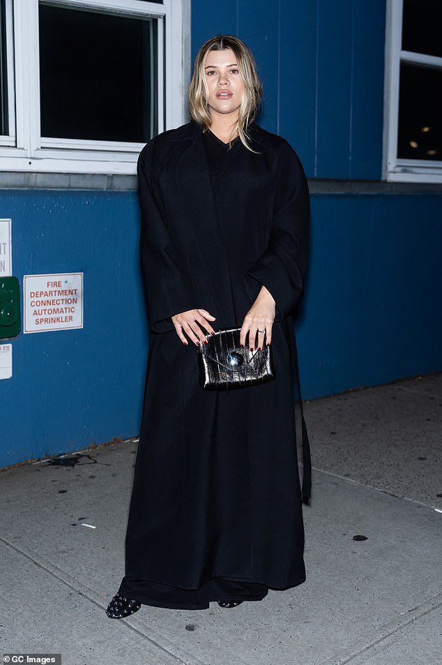 The mom-to-be, 25, stole the spotlight as she cradled her baby bump in a chic black trench coat