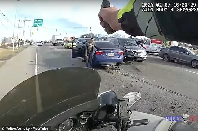 Bodycam video from another officer tracks the vehicle to a police motorcycle.  The video begins with the Toyota Camry now parked and Graham crouched next to it, visibly injured