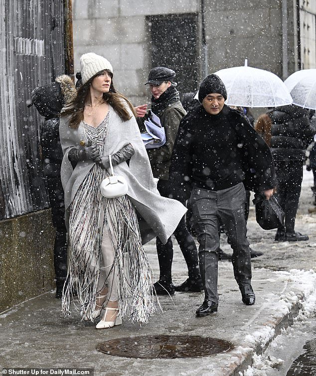 One participant wore a fringed dress, gray sweater and hat as she stepped through the melting snow
