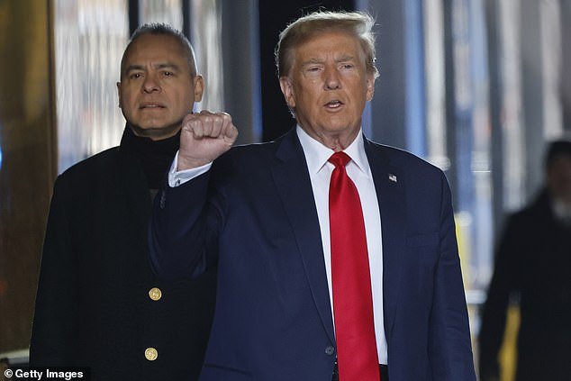 Trump raises a fist as he acknowledges cameras and reporters as he leaves Trump Tower in New York City on Thursday en route to a pre-trial hearing at Manhattan Criminal Court in the case in which he was charged with 34 counts of falsifying corporate records
