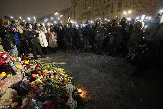 People wave their mobile phones with flashing lights and pay their respects to Navalny in St. Petersburg