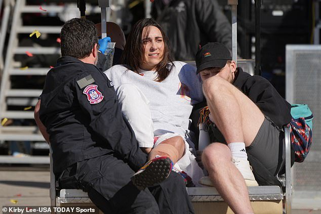 An injured fan receives aid and is taken away from the scene of the shooting