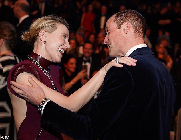 Cate Blanchett places her arm on the Prince of Wales's shoulder as the couple greets each other