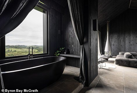 The bed faces a retractable window where views of the countryside are shown, while a freestanding black oval bath hides in its own 'ritual room' with curtains and a freestanding bath