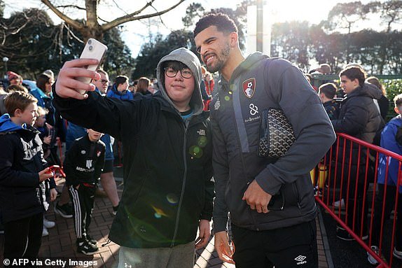 Bournemouth's England striker #09 Dominic Solanke poses for a selfie photo with a fan as he arrives for the English Premier League football match between Bournemouth and Manchester City at the Vitality Stadium in Bournemouth, southern England on February 24, 2024. (Photo by Adrian DENNIS / AFP) / LIMITED TO EDITORIAL USE.  No use of unauthorized audio, video, data, fixtures, club/league logos or 'live' services.  Online use during competitions limited to 120 images.  An additional 40 images can be used in the additional time.  No video emulation.  Use of social media during competitions is limited to 120 images.  An additional 40 images can be used in the additional time.  No use in betting, competition or individual club/competition/player publications.  / (Photo by ADRIAN DENNIS/AFP via Getty Images)
