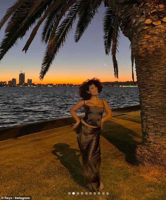 In her latest photo, the singer smiled as she posed during the sunset in a brown satin corset and maxi skirt