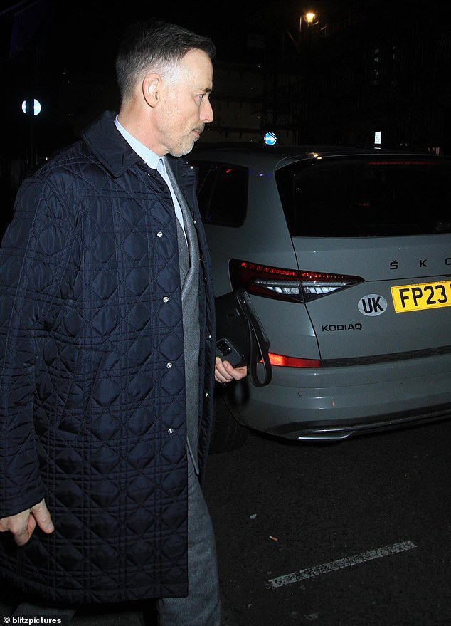 His husband David (pictured) was with him at dinner, looking dapper in a long blue padded jacket