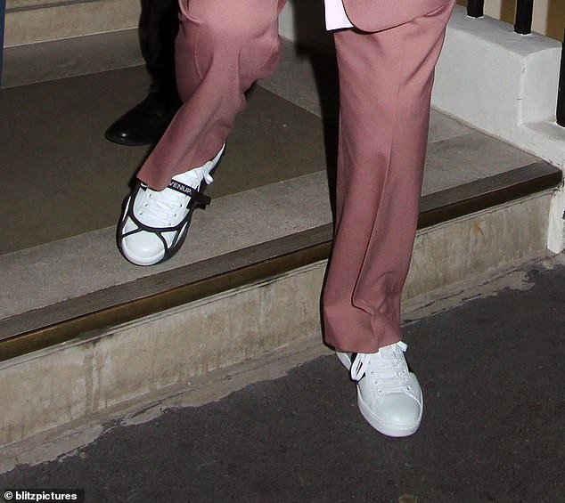 The foot brace was clearly visible over his bright white Gucci sneakers as he stepped out