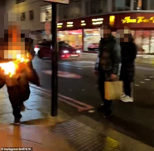 People watch in shock as the man, covered in flames, runs down a street in Edgware Road