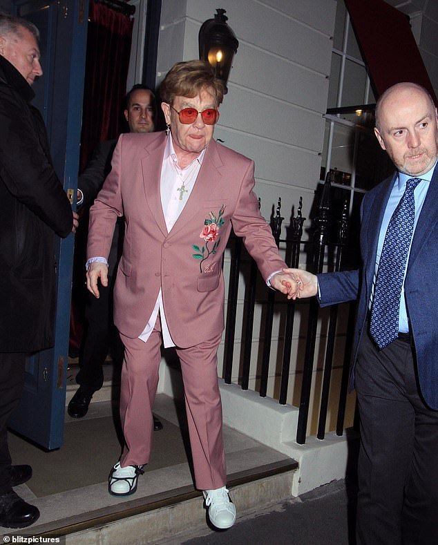 Elton John struggled to walk as he left a fancy dinner in London wearing a foot brace on Tuesday evening