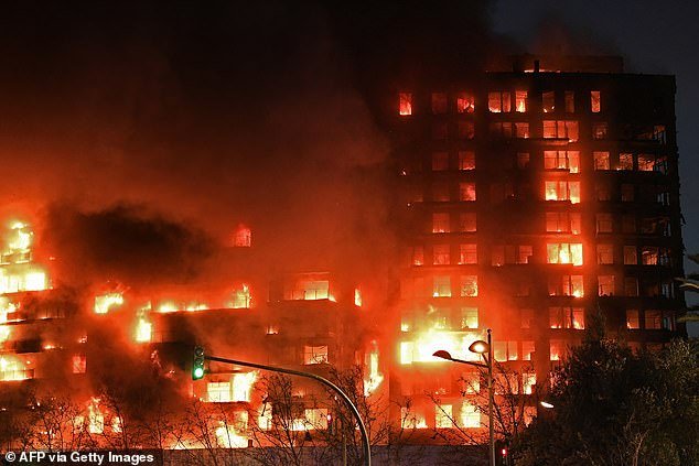 The 14-storey flat has reportedly been 'reduced to a skeleton', while a nearby building has also been consumed by the flames