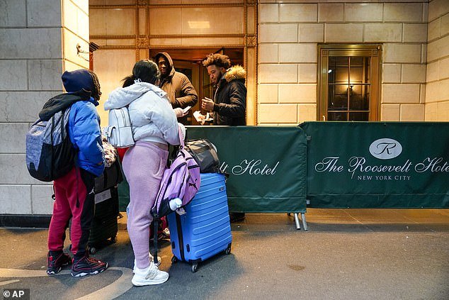 Migrants are seen outside the Roosevelt Hotel on January 9.  Families living at the hotel will participate in the prepaid card pilot, purchasing food instead of receiving meals.