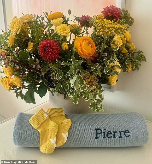 The 40-year-old supermodel shared an image of a blue baby blanket embroidered with her newborn son's name, as well as an adorable pair of yellow knitted baby booties