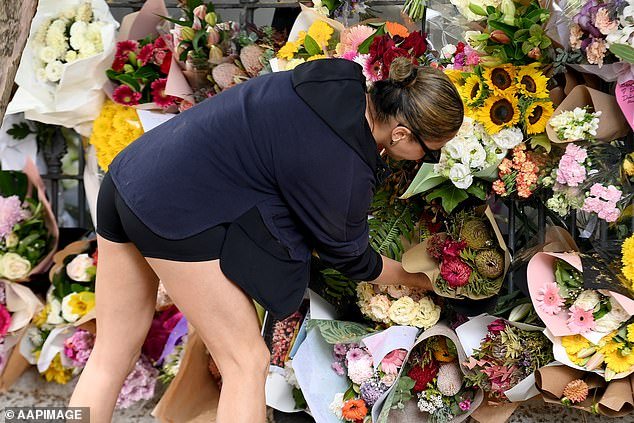 A mourner is seen leaving a bouquet of flowers outside the $2.5 million Paddington terrace