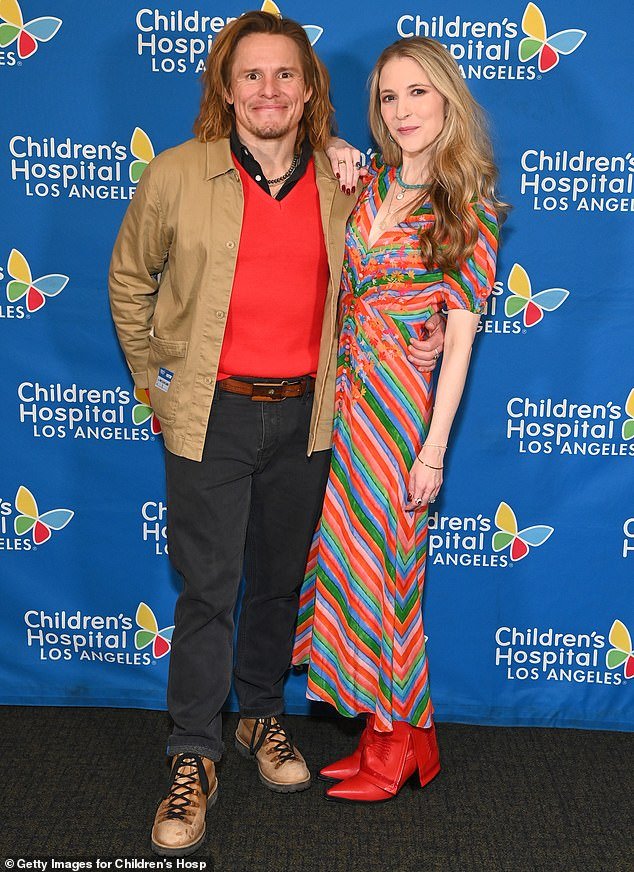 Tony Cavalero wore a bright red crew-neck sweater under a beige jacket, while his wife Annie stood out in a multi-colored dress