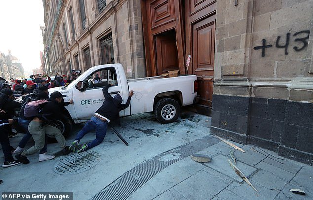 Protesters push a pickup truck to break down a door at the National Palace - the home of Mexican President Andrés Manuel López Obrador - in Mexico City on Wednesday