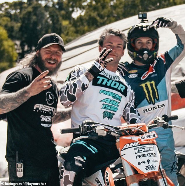 The 28-year-old (pictured center with fellow motocross racers) was practicing the triple backflip trick that made him famous when he died