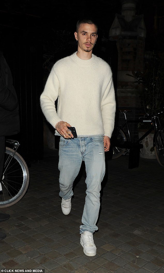 Romeo, the son of David and Victoria Beckham, cut a casual figure for the evening in a white sweater that he paired with light gray jeans