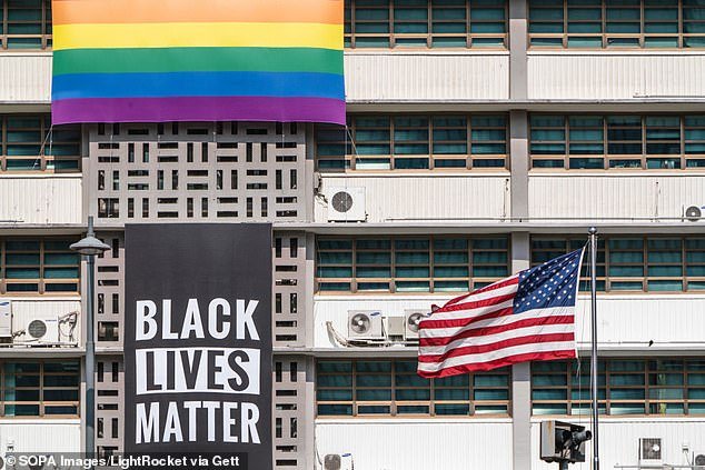 A Black Lives Matter banner, a United States national flag and a rainbow flag are hung on the facade of the US Embassy building in Seoul
