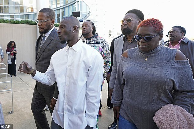 Michael Corey Jenkins, second from left, and attorney Malik Shabazz, left, are joined by supporters as they enter the Thad Cochran United States Courthouse on Tuesday
