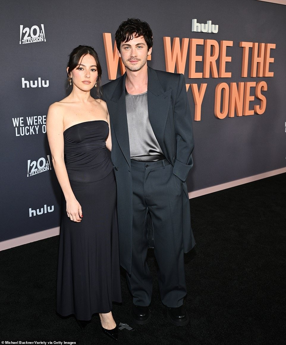 Logan brought along his fiancée of four months - multimedia artist Ana Corrigan (L) - who kept it simple in a black tube top over a matching maxi skirt and pumps