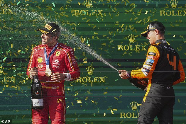 Briton Lando Norris (right) is pictured spraying Sainz with champagne after finishing third