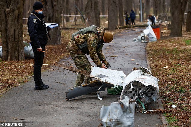 Police officers inspect part of a Russian Kh-55 cruise missile, intercepted during a missile attack, during the Russian attack on Ukraine, in a park in Kiev, on March 24
