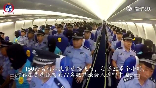The alleged perpetrators are then hooded, handcuffed and seated in the middle of a line of Chinese police officers as they are flown back to China on a charter plane (photo)