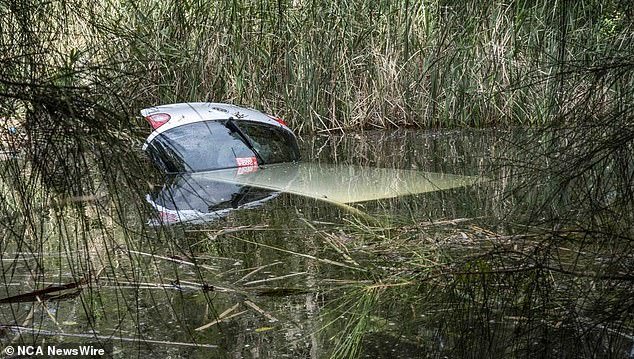 NSW Ambulance Paramedics examined the driver at the scene after Constable McJannet rescued her just seconds before the car (pictured) sank