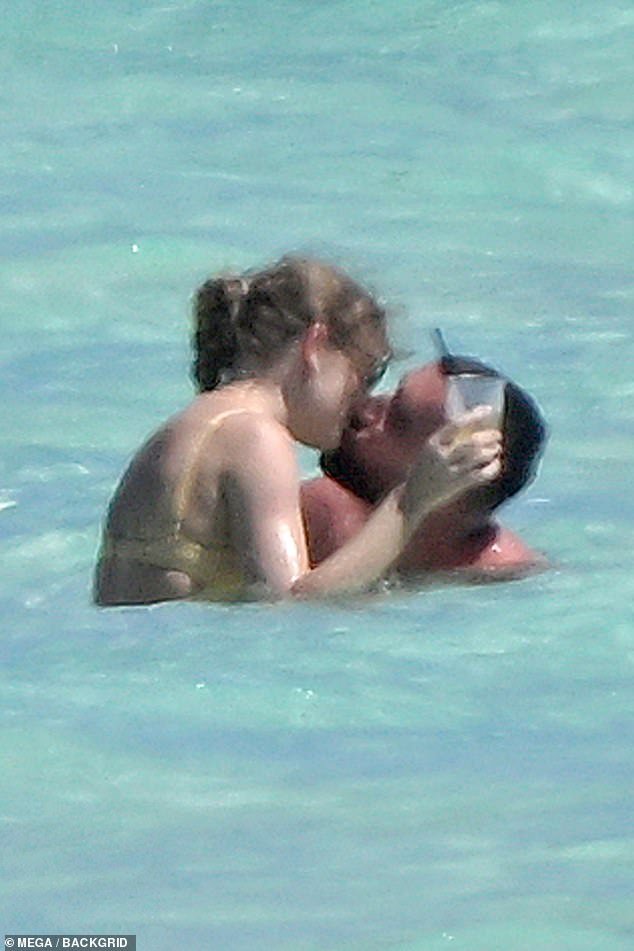 The loved-up couple, who have been dating since September, share a kiss in the ocean water while on vacation