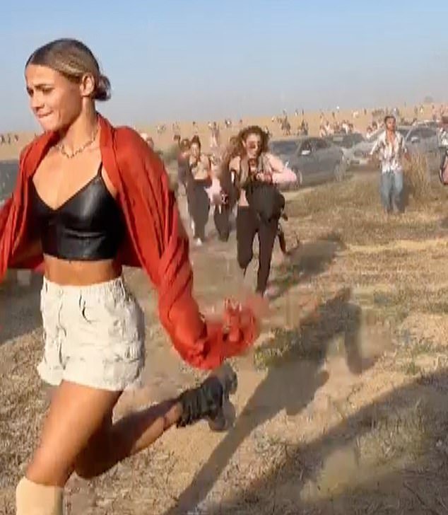 People are seen fleeing the music festival following the Hamas attack in Israel on October 7 last year