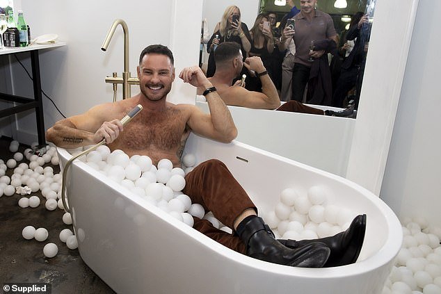 He was seen smiling and laughing as he posed in the tub while his friends and guests took photos of him