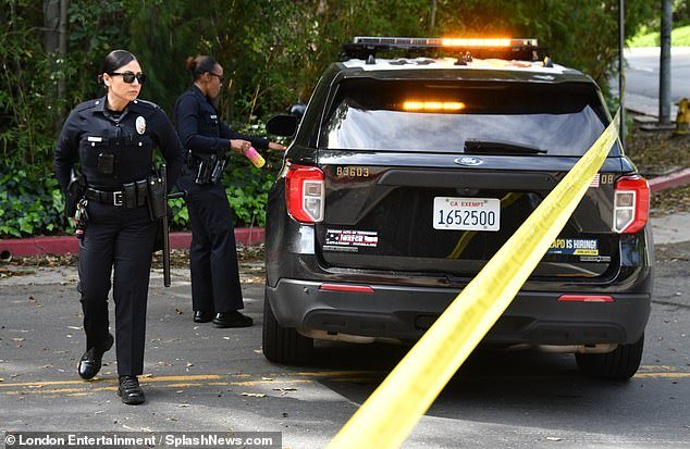 Police officers monitor the scene at Diddy's mansion in Holmby Hills