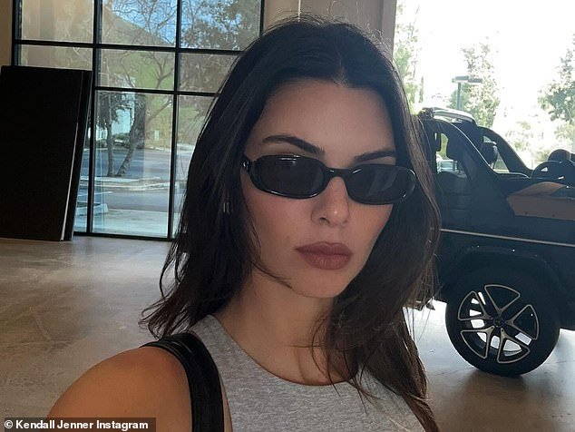Jenner's dark brown hair was styled in loose layers around her shoulders.  The cover model wore natural-looking makeup with a strong red lip and accessorized with dark sunglasses