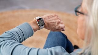 A person looks at an Apple Watch on his wrist.  The device warns them that they have a high heart rate.