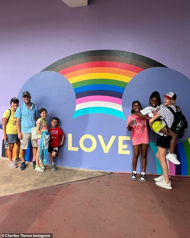 The Atomic Blonde actress posed with daughters Jackson and August in front of a rainbow mural painted with Mickey Mouse ears with the phrase 'LOVE'