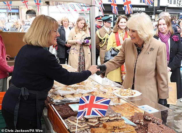 Queen Camilla meets a trader while visiting the farmers' market in Shrewsbury