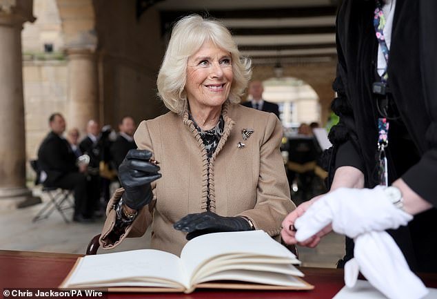 Camilla signs the visitors book at the Old Market Hall on her trip to Shrewsbury