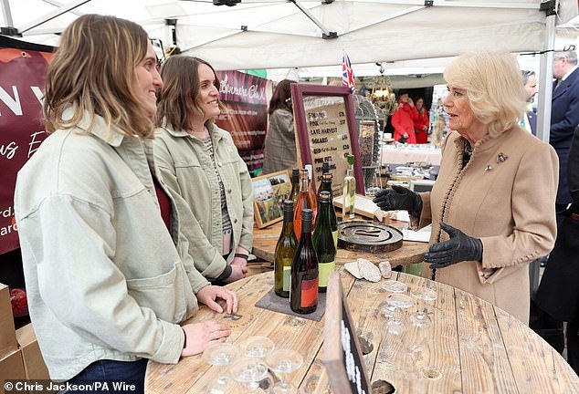 Queen Camilla speaks to market traders at a wine stall during a visit to Shrewsbury
