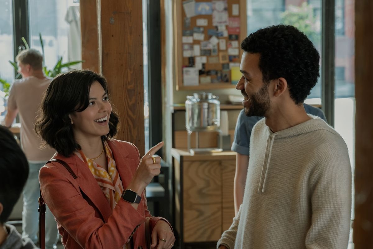 A smiling woman (An-Li Bogan) pointing to a smiling man (Justice Smith).