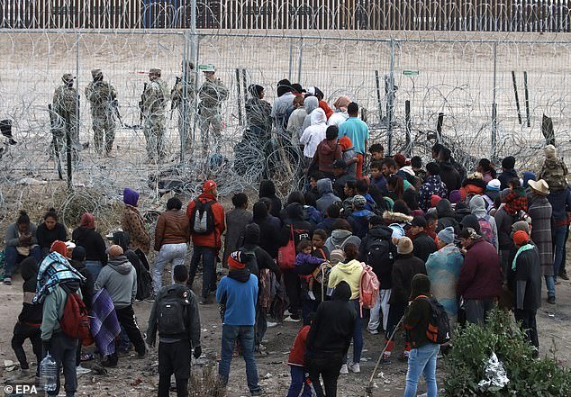 Migrants gather as they try to enter US territory through the razor fence at the border in Ciudad Juarez, Chihuahua state, northern Mexico, March 20, 2024