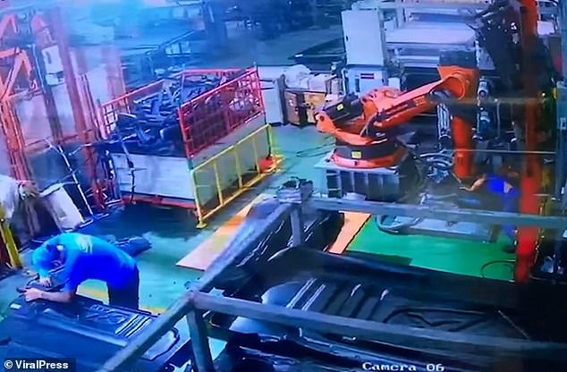 Disturbing CCTV footage shows the victim becoming incapacitated beneath the colossal metal contraption, while a colleague continued to work across the room, seemingly oblivious to the catastrophe unfolding just behind him.