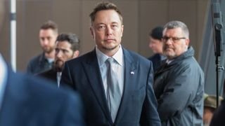 Elon Musk wears a suit and walks through New York