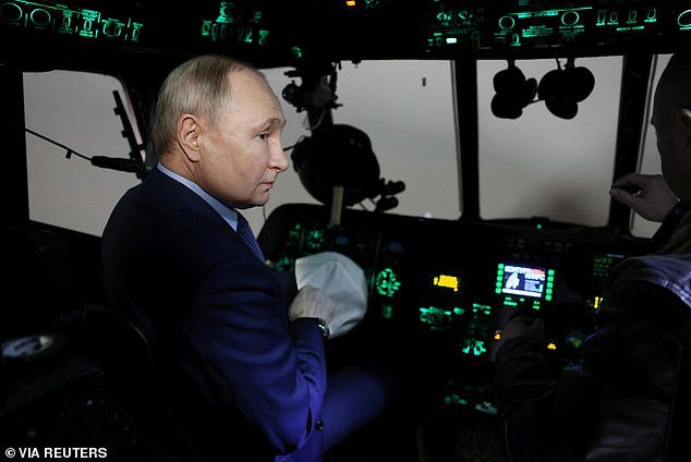 Putin sits in a flight simulator during a visit to a pilot training school in the Tver region