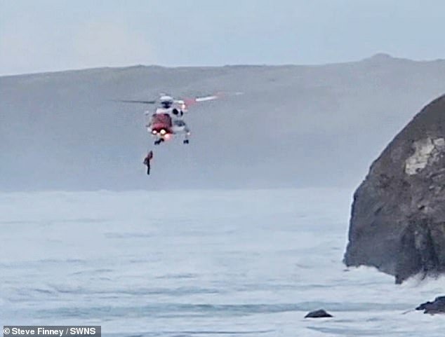 Mobile phone footage shows how precarious the man's position was after he was airlifted above the raging tides.  Presumably he fell on the rocks