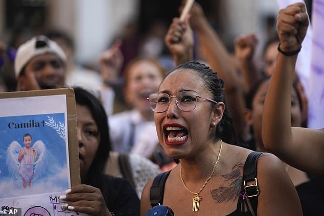 A woman chants the Spanish word for "justice" during a demonstration against the kidnapping and murder of an 8-year-old girl, in the central square of Taxco, Mexico, Thursday