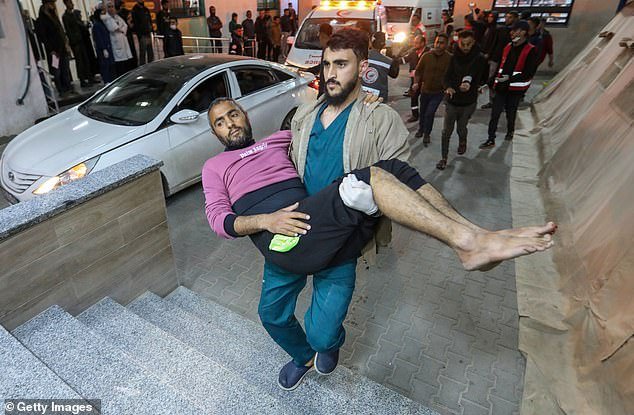 A Palestinian injured in an Israeli airstrike arrives for treatment at Kuwait Hospital