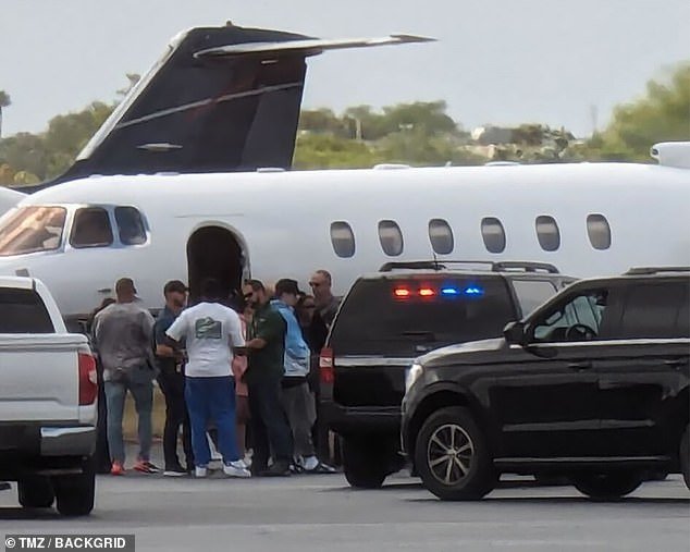Diddy is pictured talking to police outside his private jet as they arrested the man accused of being the rapper's drug mule on Monday