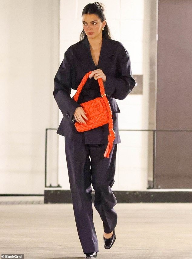 Kendall Jenner draped her slim supermodel frame in a dark ensemble that enhanced her 5'11" height this week